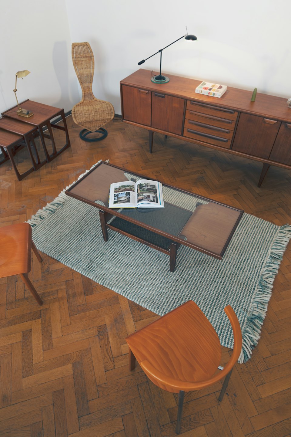 Mid-century modern furniture arranged on a striped rug.